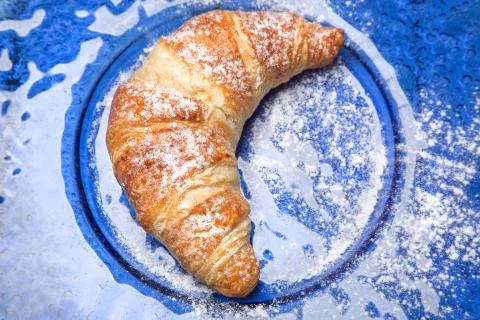 Sweet roll on blue plate Stock Photos