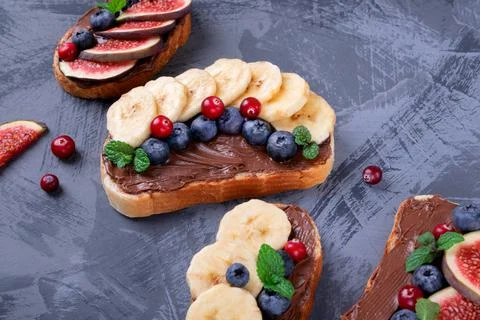Sweet sandwiches assortment with banana, chocolate nut butter, blueberry Stock Photos