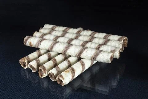 Sweet sticks with stuffing on the table with reflection. Stock Photos