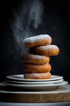 Sweet Sugar Donuts in stack being dusted with icing sugar Stock Photos