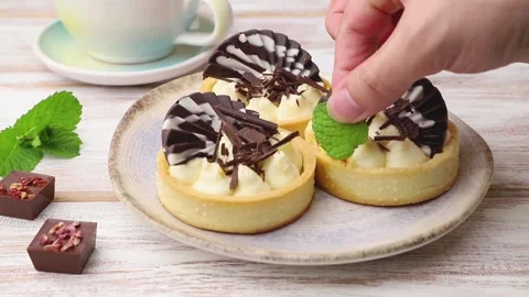 Sweet tartlets with chocolate and cheese cream on white wooden background. Stock Footage 141532453