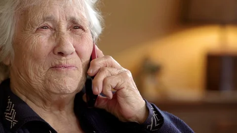 Sweet toothless elderly lady talking on mobile 스톡 동영상 129752901