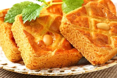 Sweet waffle bread with peanuts on plate Stock Photos