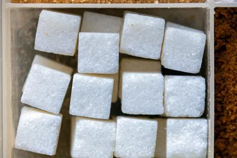 Sweet white sugar cubes texture pattern in plastic bowl Stock Photos