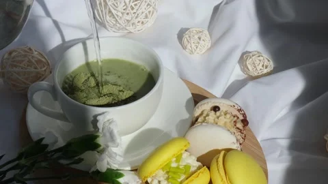 Sweet yellow macaron dessert Process of preparation green plant based matcha tea Stock Footage 309315711