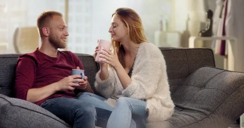 Sweet young couple drinking tea on couch Stock Footage