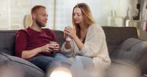 Sweet young couple drinking tea on couch Stock Footage