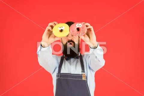 Sweets and cakes. Junk food. Hipster bearded baker hold donuts. Eat donut Stock Photos