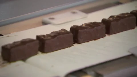 Sweets in chocolate move quickly along the conveyor Video stock 94873150