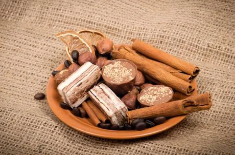 Sweets, cinnamon, nuts and coffee beans on a saucer Stock Photos