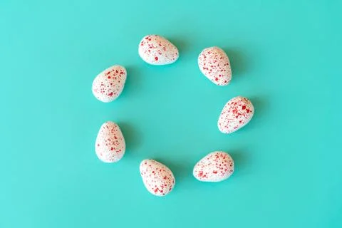 Sweets in the form of quail eggs on a blue background lined with a round frame Foto stock