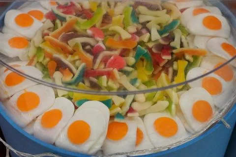 Sweets in the form of scrambled eggs and sweet multicolored worms in a plastic b Foto stock