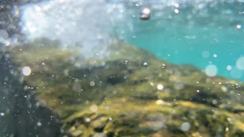 Swells twist bubble trails into spiral formations, pushing them through the Stock Footage 313668636