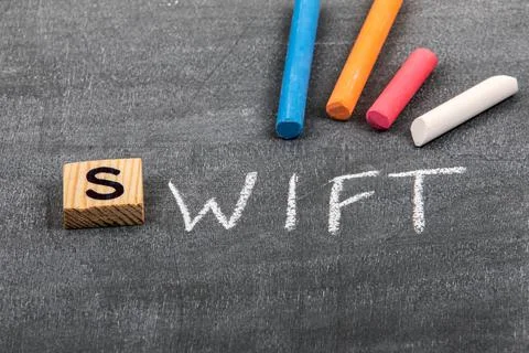 Swift code and programming language concept. Colored chalk pieces on a black Foto stock