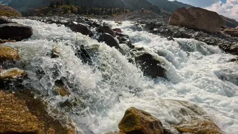 A swift mountain river surrounded by a rocky landscape 動画素材 317705772