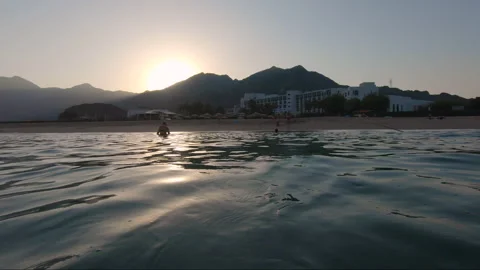 A swim in the ocean at sunset Stock Footage 220283114