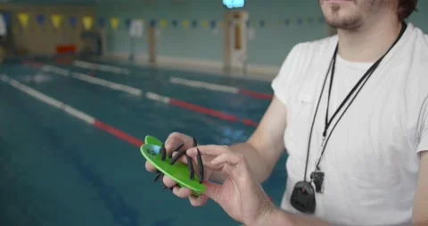 Swim trainer showing how to use paddles Stock Footage 169465751