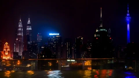 Swiming pool on the edge of rooftop and night cityscape of Kuala Lumpur Stock Footage 93679312