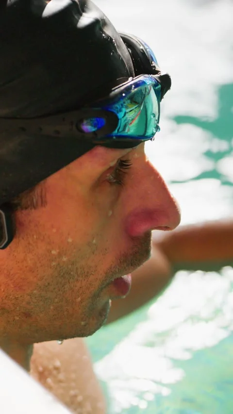 Swimmer with cap and goggles, looking focused in pool water Stock Footage 346457022