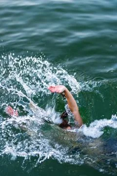 Swimmer captured in vigorous motion creating splashes in open water Stock Photos