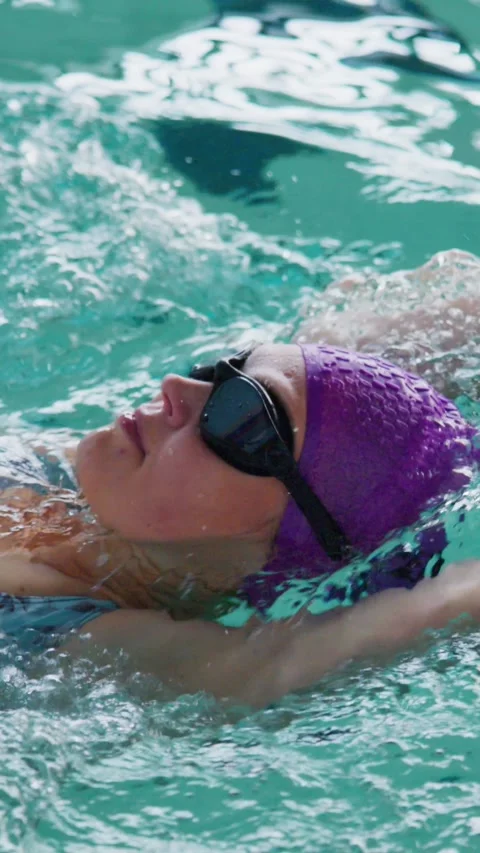 Swimmer glides through clear pool water with relaxed focus Stock Footage 346458859