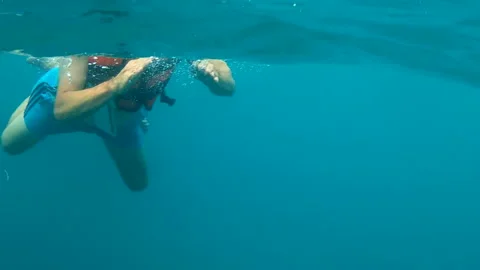 A swimmer glides through clear, turquoise water 動画素材 313283263