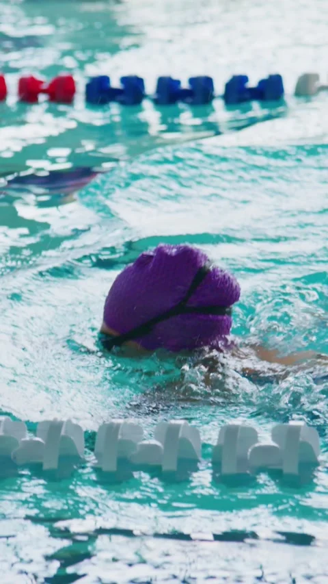 Swimmer glides through lane marked by red and blue buoys Stock Footage 346458422
