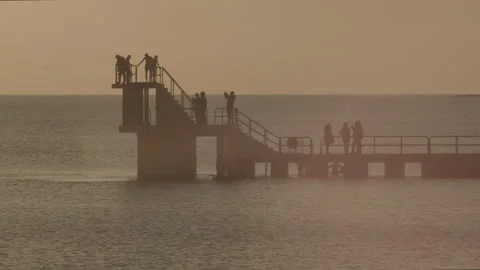 Swimmer Jumping Off Diving Tower In Irish Winter Afternoon Sun Stock Footage 149834451