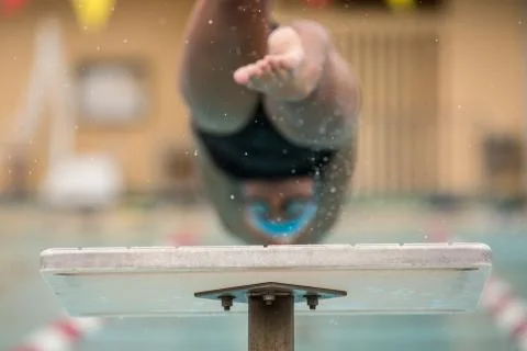 Swimmer jumping off platform Stock Photos