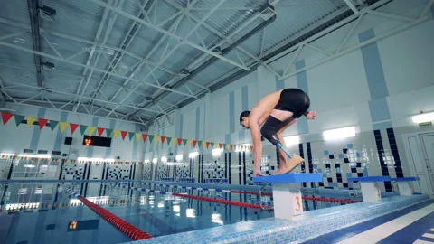 Swimmer with a leg prosthesis jumps into the pool, close up. Stock Footage 99534199