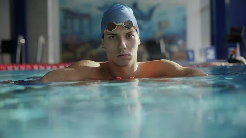Swimmer looking at camera leaning on the dividing path in the pool Stock Footage 97225659
