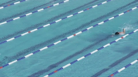 Swimmer in outdoor lane pool doing laps Stock Footage 104934448
