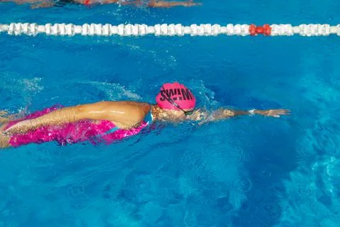 Swimmer performing front crawl stroke in clear blue swimming pool water dur.. Stock Photos