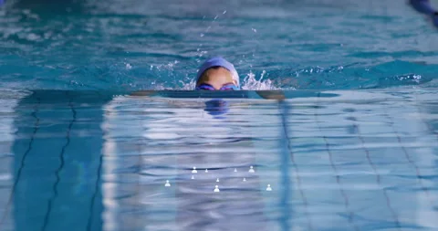 Swimmer pushing off pool with cap, goggles, executing breaststroke pull, Stock Footage 315549601