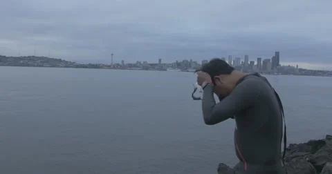 Swimmer puts on cap. Seattle background. Stock Footage 40274146
