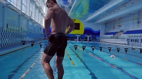 Swimmer stands on a tower in the pool Stock Footage 79614393
