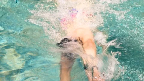 Swimmer trains in pool. Young athletic man wearing swimming goggles  Vídeo Stock 178006822