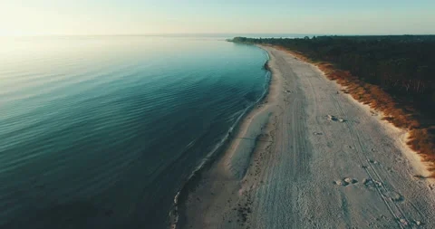 Swimmer walking at the beach sunset alone lonely aerial drone coastline ocean Stock Footage 153500694