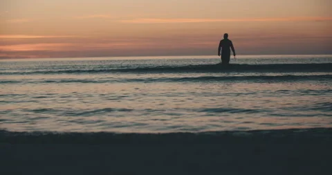 Swimmer wetsuite sunset ocean silouhette 4k slowmotion Video stock 153500832