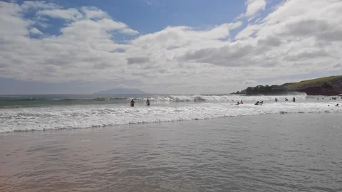 Swimmers and surfers enjoying the waves Stock Footage 123760990