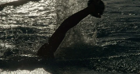 Swimmers backlit in open air pool using hand paddles. Vídeos de archivo 86139375