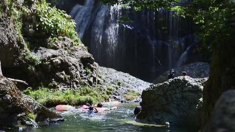 Swimmers enjoying a cool mountain stream near waterfalls Stock Footage 249443041