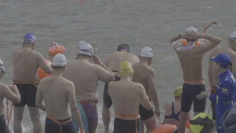 Swimmers Exiting Gan River After Race With Officials At Riverside Vídeos de archivo 343554903