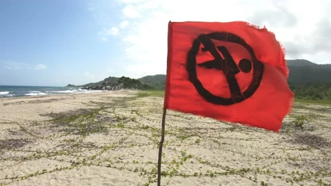 Swimming forbidden red flag, close up and back dolly - Tayrona - Colombia 4K Stock Footage 166462052