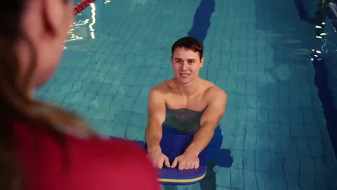 Swimming instructor teaches a young guy how to swim in the pool.Swimming in an Stock Footage 208632515