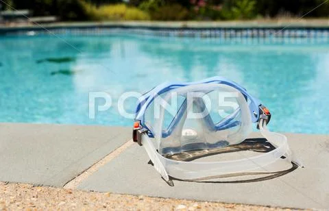 Swimming mask by side of blue pool Stock Photos