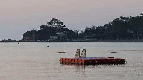 A swimming platform sways on the waves in the early morning Stock Footage 126762912