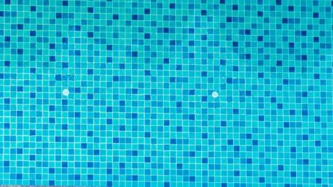 Swimming pool bottom is source tiles and water waves background. Stock Photos