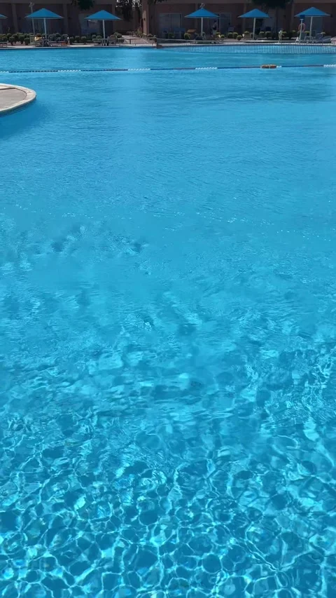Swimming pool with clear blue water at a sunny summer hotel on June 20, 2026 in Stock Footage 337295932