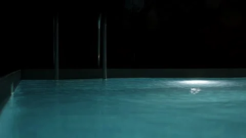 Swimming pool with clear blue water and bright underwater lights at night. Stock Footage 340125284
